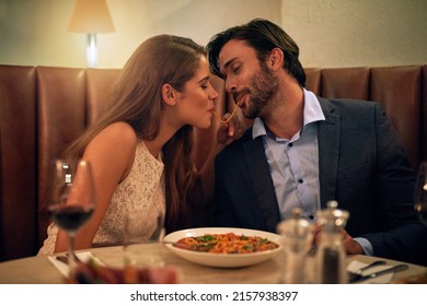 Love bites. Shot of a young couple sharing spaghetti during a romantic dinner at a restaurant. - Powered by Shutterstock