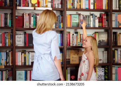 I Love Books. Young Blond Girl Reaching For A Book In The Library.