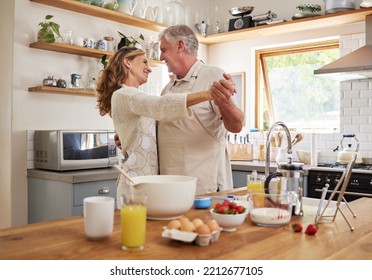 Love, Breakfast And Senior Couple Dance In Kitchen For Romance And Happy Life Together In House. Married Retirement People Smile With Happiness Enjoying Cooking Dancing Break In Canada Home.