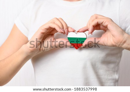 Love Bulgaria. The girl holds a heart in the form of the flag of Bulgaria on her chest. Bulgarian concept of patriotism