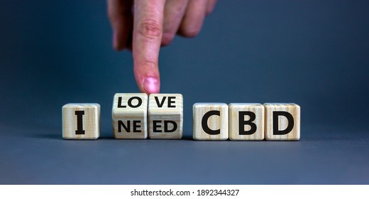 I love CBD, cannabidiol symbol. Hand turns cubes and changes words 'I need CBD' to 'I love CBD'. Beautiful grey background, copy space. Medical and i love CBD cannabidiol concept.