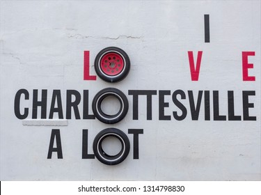 I LOVE CHARLOTTESVILLE A LOT roadside attraction sign made with tires mounted on white wall.