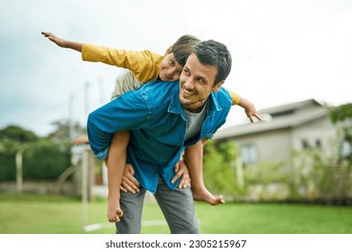 Love, children and a son on back of his dad outdoor in the garden to fly like an airplane while bonding together. Family, kids and a father carrying his male child while playing a game in the yard - Powered by Shutterstock