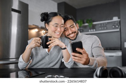 Love, coffee and couple with phone in home kitchen watching video online. Social media, tea and diversity of man and woman with mobile smartphone streaming movie or film and bonding at night in house - Powered by Shutterstock