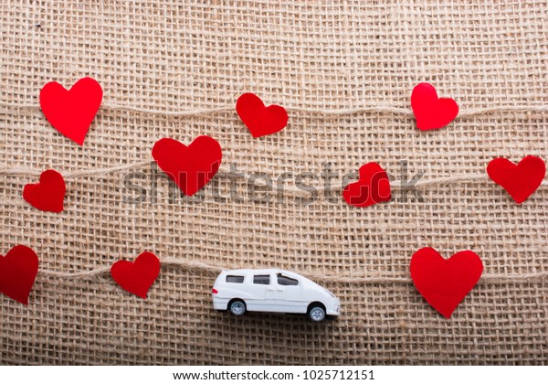 Love\
concept with car and paper heart on linen\
threads