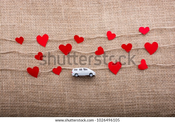 Love\
concept with car and paper heart on linen\
threads