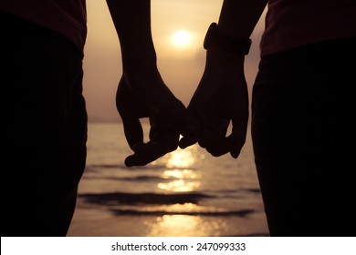 love couple holding hands fingers at sunset on the beach, valentine day