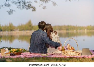 In love couple hugging together enjoying picnic time in park outdoors Picnic. happy couple relaxing together with picnic Basket. - Powered by Shutterstock