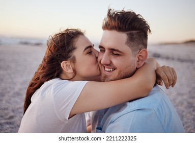 Love, Couple And Kiss On Beach Happy To Celebrate Relationship With Sunset Being Relax, Smile And On Holiday. Romance, Man And Woman Hug, Embrace And Bonding On Seaside Vacation Together Outdoor.