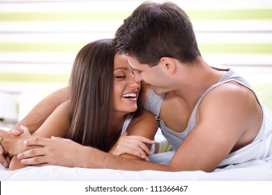 Love Couple Lying In Bed Kissing And Looking Each Other