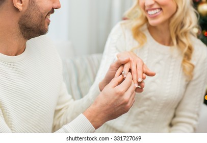 Love, Couple, Relationship And Holidays Concept - Happy Man Giving Diamond Ring To Woman For Christmas