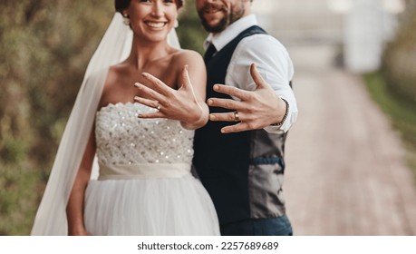 Love, couple and showing ring outdoor, happiness and celebration for relationship, achievement and loving. Romance, man and happy woman with diamonds, bonding and romantic on wedding day and ceremony