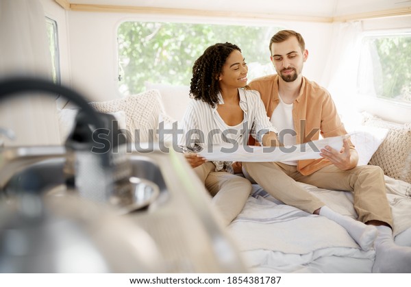 Love couple\
sitting in bed, camping in a\
trailer
