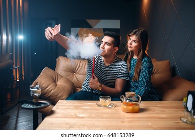 Love Couple Smokes Hookah At The Bar