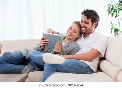 In love couple using a tablet computer in their living room