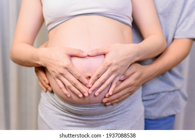 Love couple using their hands to mark the heart shape. Family lifestyle of pregnancy.