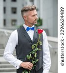 love day concept. adult tuxedo man with love rose. flower gift for love day