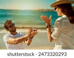 Love, engagement and couple on a beach, happy and relationship for commitment, vacation and support. Surprise, man and woman on seaside holiday, proposal and ask for hand in marriage for romance