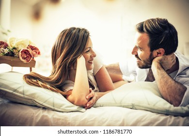 Love in the eyes. Happy couple in bed. Space for copy.