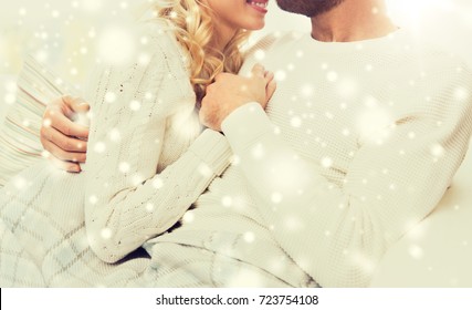 Love, Family, Winter And Happiness Concept - Close Up Of Happy Couple Cuddling Under Paid At Home