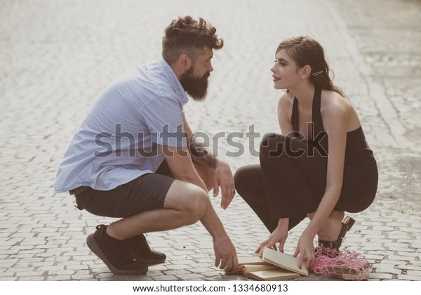 Love at first sight. Man and woman falling in\
love. Bearded man and cute woman met on street. Hipster helping and\
looking at pretty girl. Couple in love on summer day. Enjoy\
romantic date and dating.