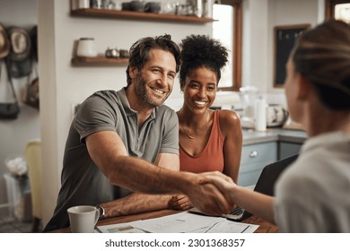 Love, handshake and couple with a financial advisor, consultation and discussion for investments. Partners, man and woman with a consultant, home and conversation for advice, help and shaking hands - Powered by Shutterstock