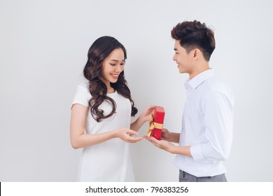 Love. Handsome Young Vietnamese Man Giving Present To Beautiful Woman At Home