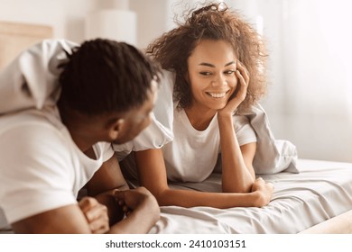 Love And Happiness. Loving Black Spouses Smiling To Each Other Enjoying Romantic Morning In Bedroom, Lying Under Blanket And Flirting Having Intimate Moment In Bed At Home - Powered by Shutterstock