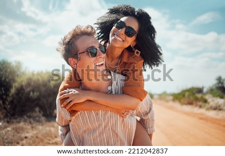 Love, happy and couple piggy back on road path in Arizona desert in USA for romantic getaway. Interracial people dating smile while enjoying summer romance on travel holiday adventure together.