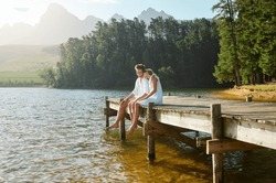 Love, Happy And Deck With Couple At Lake For Bonding, Romance And Affectionate Date. Nature, Travel And Holiday With Man And Woman Cuddling On Boardwalk In Countryside For View, Summer And Vacation
