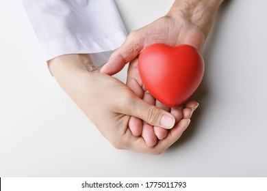 Love And Healthcare Concepts, Red Heart In Hands, Doctor Holding Senior Patient Hand To Giving Support, Organ Donate And Health Charity.