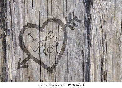 Love heart and arrow graffiti carved into old wood