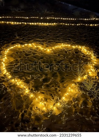 Love heart in fairy lights in dark sand