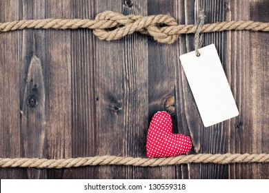 Love heart on vintage wooden planks with rope and paper tag background - Powered by Shutterstock