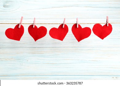 Love hearts hanging on rope on a blue wooden background