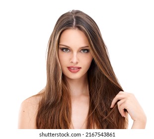 In love with her locks. Portrait of a beautiful young woman smiling and holding a strand of her long hair against a white background.