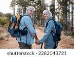 Love, hiking and portrait of old couple holding hands on nature walk in mountain forest in Canada. Travel, senior man and woman on hike with smile on face and health on retirement holiday adventure.