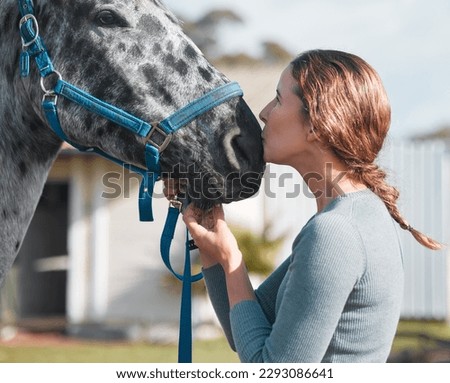 I love him so. an attractive woman being affection with a horse on a farm.