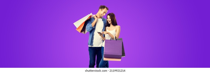 Love, Holiday Sales, Shop, Retail, Consumer Concept - Happy Smiling Couple With Shopping Bags And Cellphone. Valentines Day Holiday. Purple Violet Color Background. Wide Banner Composition Image. Wide