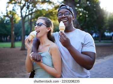 Love, ice cream or couple of friends in a park walking on a romantic date in nature in an interracial relationship. Romance, black man and happy woman eating or enjoying a snack on a holiday vacation - Powered by Shutterstock