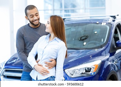 Love Is. Beautiful Happy Loving International Couple Embracing Smiling At Each Other Posing In Front Of A New Car At The Dealership Copyspace Love Anniversary Relationship African Caucasian Concept