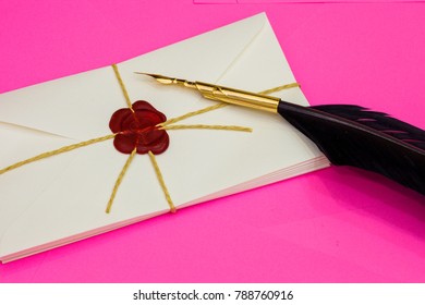 Love letter with red wax seal and feather pen on pink background