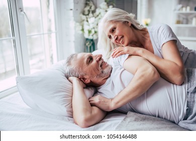 Love lives forever! Senior couple at home. Handsome old man and attractive old woman are enjoying spending time together while lying in bed. - Powered by Shutterstock