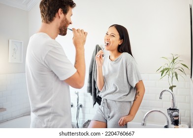 Love, morning and couple in bathroom brushing teeth together doing daily routine, happy and smile. Man and woman with good dental health, mouth care and cleaning teeth with toothbrush and toothpaste - Powered by Shutterstock