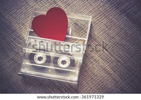 Love music concept. Valentines day background with audio tape cassette and a red heart. Cross processed image with shallow depth of field