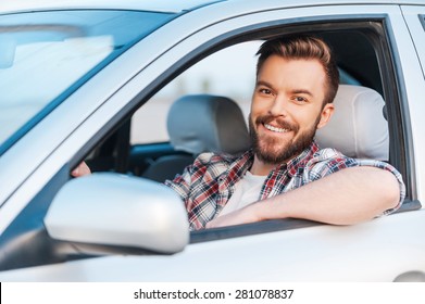 I Love My Car! Handsome Young Man Driving His Car And Smiling At Camera