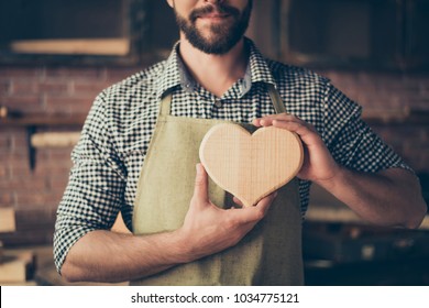 I love my job! Cropped close up photo of happy cheerful joyful carpenter in love, he is showing a heart made of wood