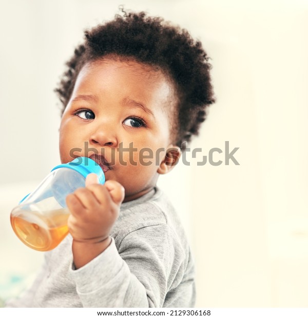 I love my sippy cup. Shot of a little baby\
boy drinking froma sippy cup at\
home.