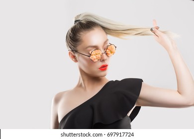 Love my style and ponytail. Woman girl with coral floral flowers sung glasses pulling touching showing her blonde gradient from brunette dark hair in braid isolated on white light grey background wall