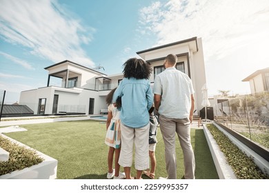 Love, new house and family in their backyard together looking at their property or luxury real estate. Embrace, mortgage and parents with their children on grass at their home or mansion in Canada. - Powered by Shutterstock